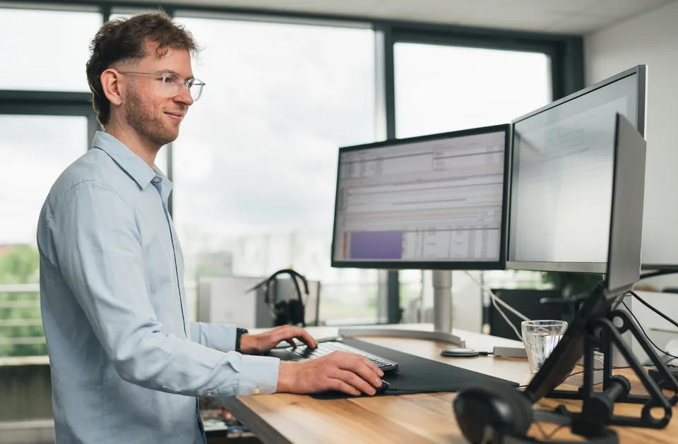 Firmware engineer analysing runtime and debug data across multiple monitors